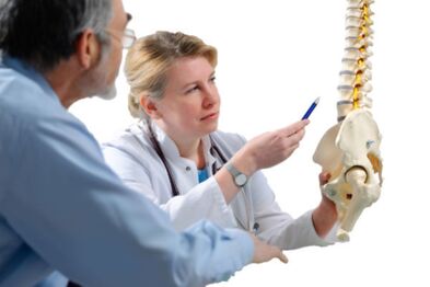 Lékař konzultuje s pacientem známky osteochondrózy hrudní páteře